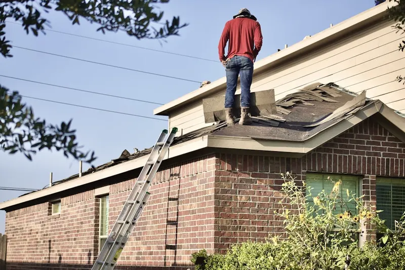 Professional roofer working on a residential roof in Blue Point